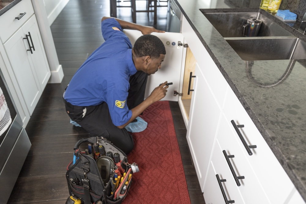 employee inspecting under the sink area