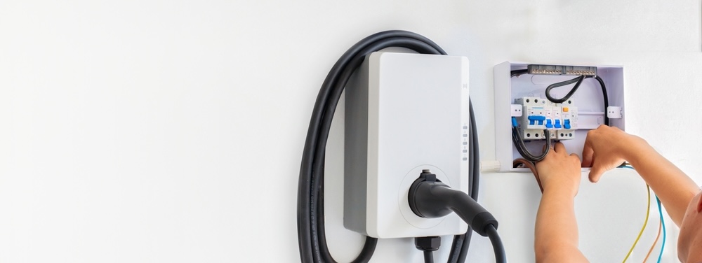 Certified male Electrician Installing Home EV Charger